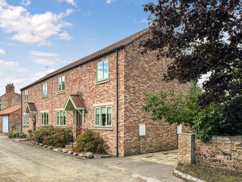a brick building with a street in front of it at Beckside Cottage in Bishop Monkton