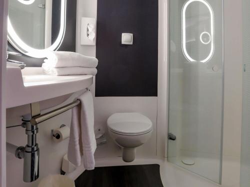 a bathroom with a toilet and a sink and a shower at ibis Haguenau Strasbourg Nord in Haguenau