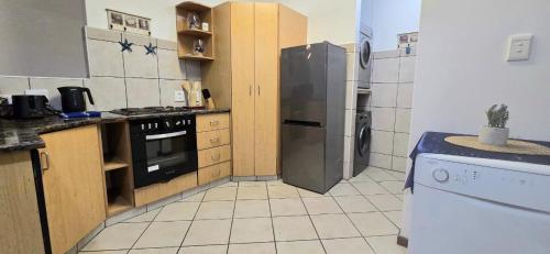 a kitchen with a refrigerator and a stove at 102 L'escalier Cabanas- Beachfront Paradise in Amanzimtoti