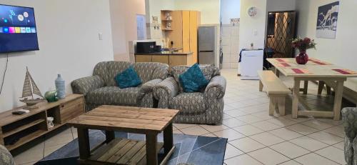 a living room with two couches and a table at 102 L'escalier Cabanas- Beachfront Paradise in Amanzimtoti