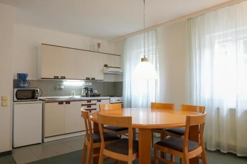 a kitchen with a wooden table and chairs in a kitchen at Apartmány Holiday Pec in Pec pod Sněžkou