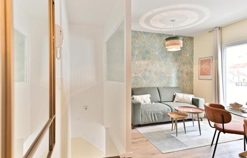 una sala de estar con un sofá y una mesa en Appartement avec balcon proche de la capitale - II, en Bagnolet