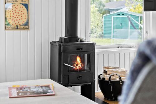 a stove with a fire in a room with a table at 30171-Odder-Pouli-Nielsensvej-71 in Beder