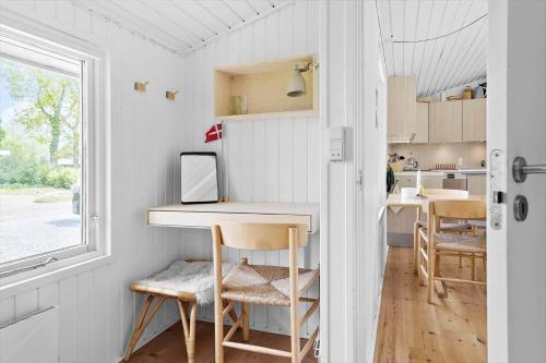 a kitchen with a table and chairs in a tiny house at 30171-Odder-Pouli-Nielsensvej-71 in Beder