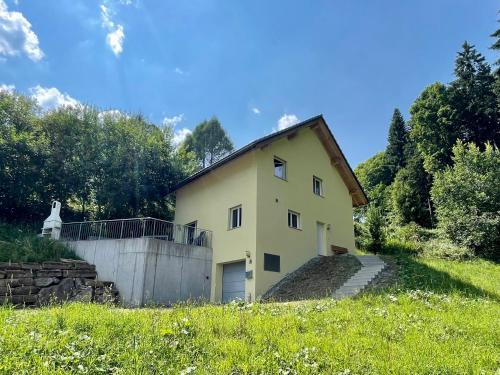 a small yellow house on a hill in a field at Haus Heimetli - CharmingStay in Flumserberg