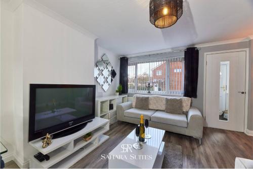 a living room with a television and a couch at Long Stays - Cosy 3BR - Newcastle Retreat - RVI & City Centre - Garden - Parking - Near High Street in Kenton