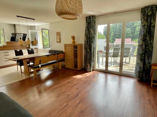 a living room with a ping pong table and a kitchen at Haus Heimetli - CharmingStay in Flumserberg
