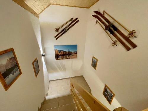a room with a staircase with skis on the wall at Haus Heimetli - CharmingStay in Flumserberg