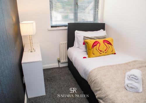 a bedroom with a bed with a yellow pillow on it at Long Stays - Cosy 3BR - Newcastle Retreat - RVI & City Centre - Garden - Parking - Near High Street in Kenton