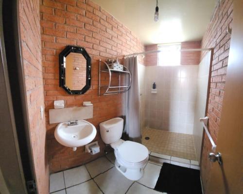 a bathroom with a white toilet and a sink at Hermosa Casa en Guanajuato Capital in Yerbabuena