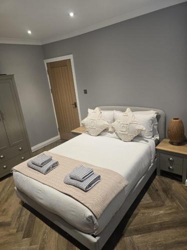 a bedroom with a bed with two towels on it at 4 bed house close to Allianz Stadium, LHR and London 20mins away in Hounslow