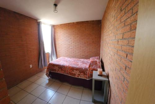 a small bedroom with a bed in a brick wall at Hermosa Casa en Guanajuato Capital in Yerbabuena