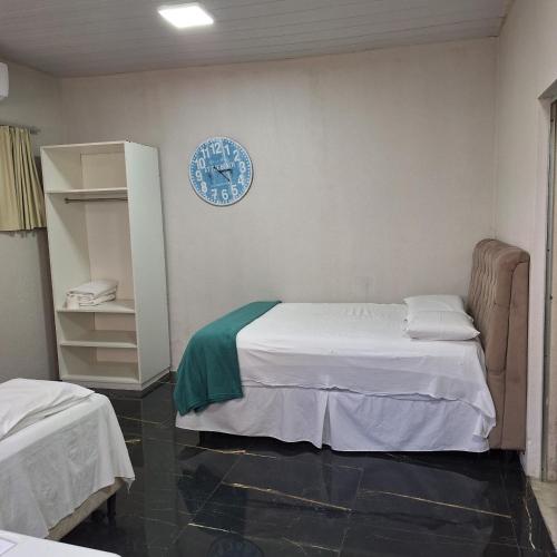 a bedroom with a bed and a clock on the wall at Pousada da Celma in Fortaleza