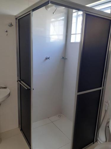 a shower with a glass door in a bathroom at Pousada Am confort turiuba ltda in Turiúba