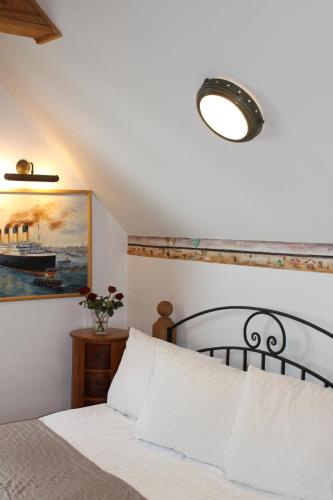 a bedroom with a bed and a painting of a ship at Apartament Bałtycki in Mielno
