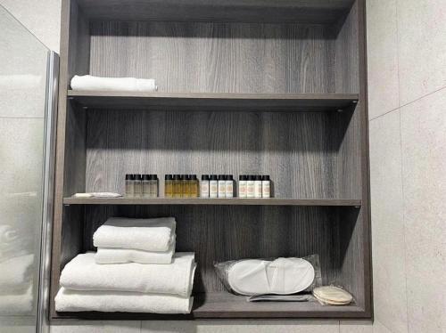 a shelf with towels and other items in a bathroom at Marina Batumi Sea View in Batumi