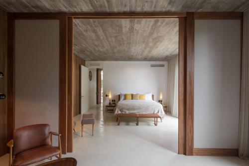 a bedroom with a bed and a large glass doorway at Posada Ayana - Adults Only in José Ignacio