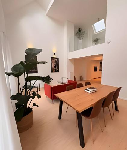 a living room with a wooden table and a plant at Montgomery Rooms & Suites in Brussels