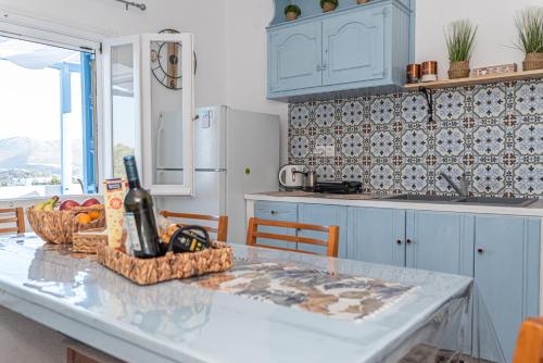 cocina con mesa y botella de vino en Monopetra View Leros, en Vromolithos