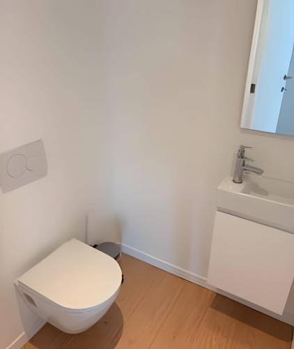 a bathroom with a white toilet and a sink at Montgomery Rooms & Suites in Brussels