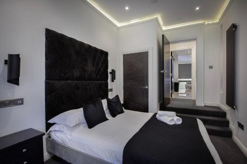 a bedroom with a large bed with a black headboard at Edinburgh City 2Bedroom & steam room! in Edinburgh