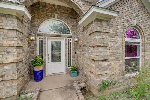 a brick house with a white door and two potted plants at 5 Acres! Countryside Getaway Outside Fort Worth in Crowley