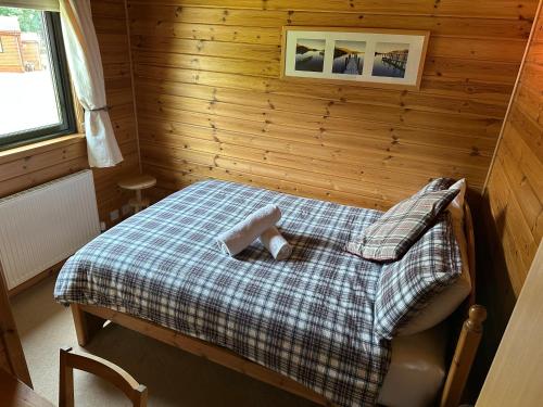 a small bedroom with a bed in a wooden room at Ben Lomond Lodge in Rowardennan
