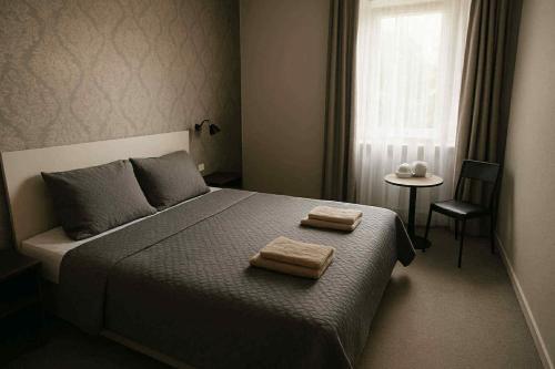 a bedroom with a bed with two towels on it at Gryfny Hotel in Wodzisław Śląski