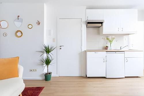 eine Küche mit weißen Schränken und einem weißen Sofa in der Unterkunft Bright & Charming Apartment in Brussels, Heart of Saint-Gilles in Brüssel