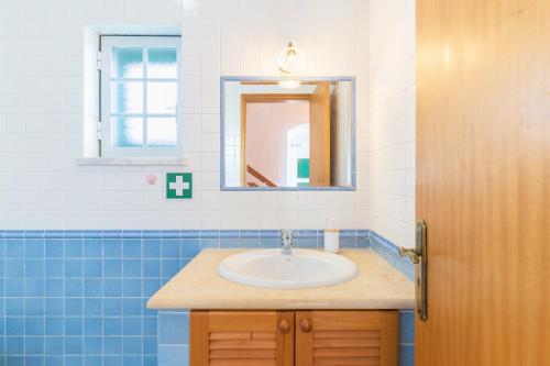 a bathroom with a sink and a mirror at Casa Margarida in Almograve