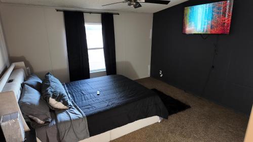 a bedroom with a black bed and a window at Faith short term rental in Romulus