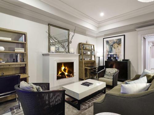 a living room with a fireplace and a couch at The Sebel Melbourne Flinders Lane in Melbourne