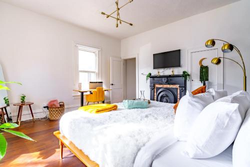 a bedroom with a large white bed and a fireplace at Prime Location Top Rated Clean Parking Free! in Chillicothe