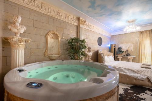 een bad in een kamer met een bed bij Olympus Grand Retreat with Jacuzzi in Athene