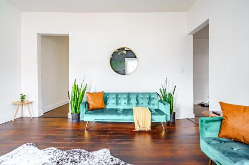 a living room with a green couch and orange pillows at Prime Location Top Rated Clean Parking Free! in Chillicothe