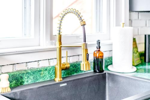 a kitchen sink with a gold kitchen faucet at Prime Location Top Rated Clean Parking Free! in Chillicothe
