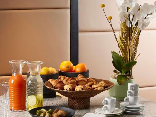 a table with a bowl of food and a bowl of fruit at Sofitel Biarritz Le Miramar Thalassa in Biarritz