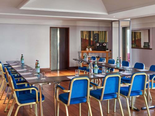 a room with long tables and blue chairs at Sofitel Biarritz Le Miramar Thalassa in Biarritz
