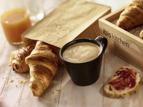 a table with a cup of coffee and some pastries at ibis Longwy Mexy in Mexy