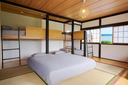 a bedroom with two bunk beds in a room at Omorica Kasumigaura - ペットOK! サウナ BBQ ピザ窯完備 貸切一軒家 - 最大7名宿泊可能 in Tabuse