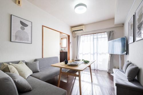 a living room with a couch and a table at Centrally Located in Matsumoto, 1 Free Parking, 2 BR APT in Matsumoto