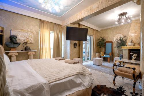 een slaapkamer met een groot bed en een televisie bij Olympus Grand Retreat with Jacuzzi in Athene