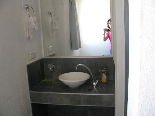 a person taking a picture of a sink in a bathroom at Balcones de Los Chorrillos in Estancia Vieja