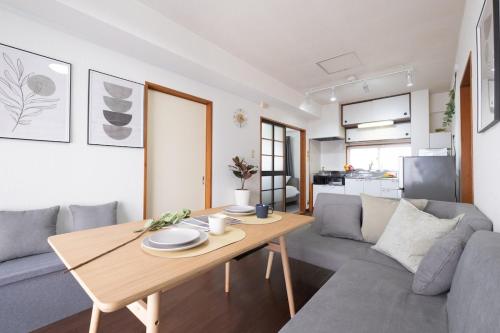 a living room with a table and a couch at Centrally Located in Matsumoto, 1 Free Parking, 2 BR APT in Matsumoto