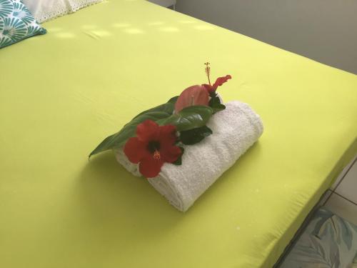 a flower on top of a towel on a table at Villa du coeur in Deshaies