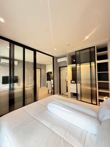 a bedroom with a large white bed and glass walls at Andaman 3 in Ban Thalat Choeng Thale