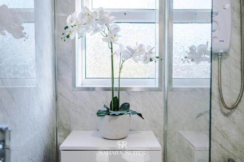 a vase of flowers sitting on a table in a bathroom at Stylish 3BED - Liverpool Centre - Parking - Sleep 5 in Liverpool