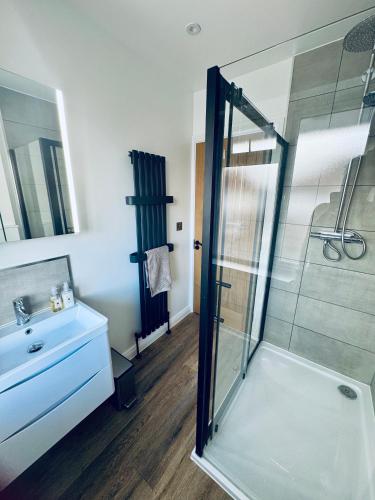 a bathroom with a glass shower and a sink at 3 bedroom Brookwood Road apartment in Southampton