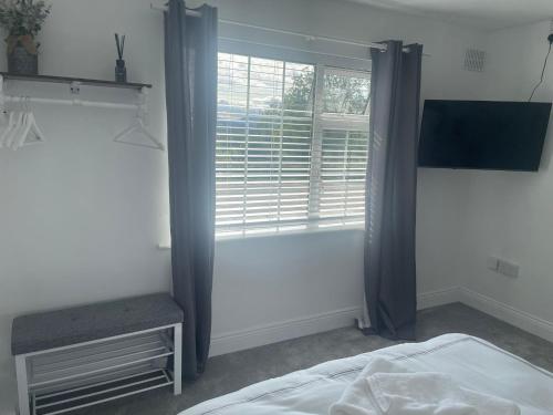 a bedroom with a window and a bed and a television at Mountaingrove bnb in Piltown