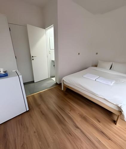 a white bedroom with a bed and a mirror at Ideal Room Near Gare du Midi in Brussels